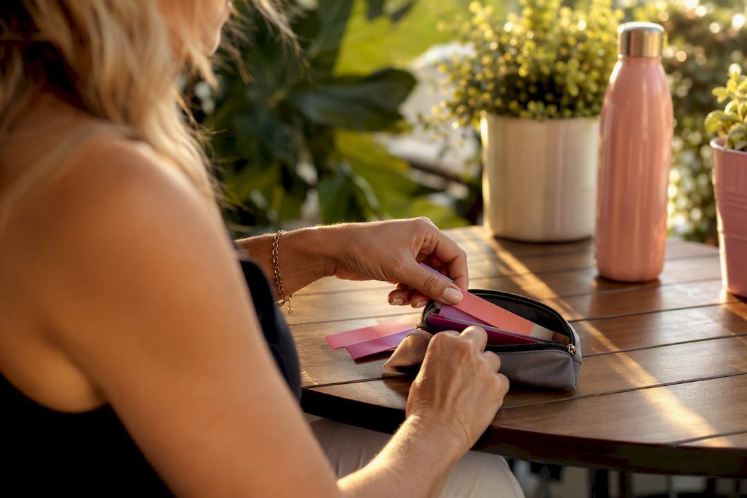 Hands packing oral supplement strips into travel pouch